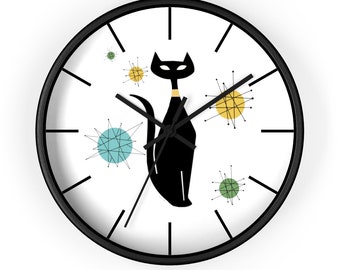 May include: A black and white clock with a black cat silhouette and colorful mid-century modern style starbursts. The clock has black hands and a black frame.
