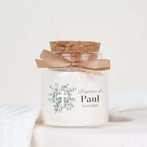 Peut inclure: Un petit pot en verre avec un couvercle en liège et une étiquette blanche. L'étiquette présente un motif aquarelle de feuilles vertes et une croix blanche. Le texte sur l'étiquette indique "Baptime de Paul 12.12.2025".