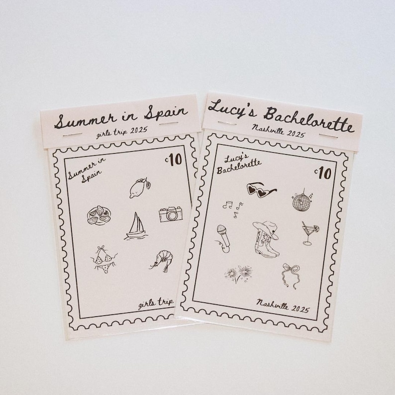 May include: Two beige paper cards with black line drawings and text. One says "Summer in Spain girls trip 2025" and the other says "Lucy's Bachelorette Nashville 2025". Each card has a stamp-like border and illustrations.