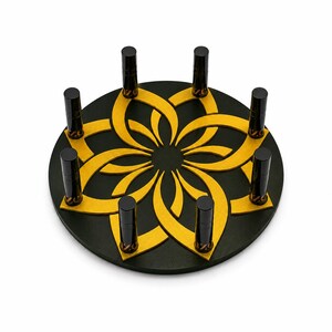 以下が含まれることがあります： 黒と金の装飾的なディスプレイスタンド、花の模様。スタンドは、金色の花の模様の円形のベースがあり、いくつかの黒い円筒形のオブジェクトを保持しています。スタンドはアイテムを保持するように設計されています。