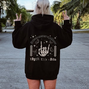 May include: Black hooded sweatshirt with a graphic print on the back. The graphic features a skeleton hand giving the 'rock on' sign with butterflies and stars. The text reads 'It was never a phase' and 'Egger Emo Club'.