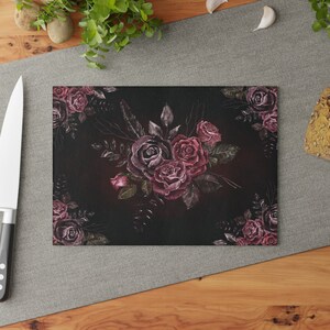 May include: A dark background with a watercolor painting of a bouquet of burgundy roses with green leaves.