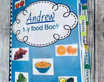 Pode incluir: Um diário de alimentos azul e branco com o título "Andrew My Food Book" e abas coloridas etiquetadas "Snacks", "Vegetais", "Frutas", "Snacks" e "Refeições".