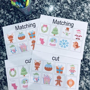 May include: Two printable Christmas-themed matching games. The first game is titled "Matching" and features images of a wreath, Christmas tree, snowman, Santa Claus, stocking, snow globe, snowflake, and a bird. The second game is titled "cut" and features images of a wreath, Christmas tree, reindeer, pudding, gift, elf, penguin, gingerbread house, gingerbread man, and an ornament.