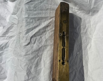 May include: A vintage wooden level with a brass inlay and multiple level indicators. The level is worn and has a rustic appearance.