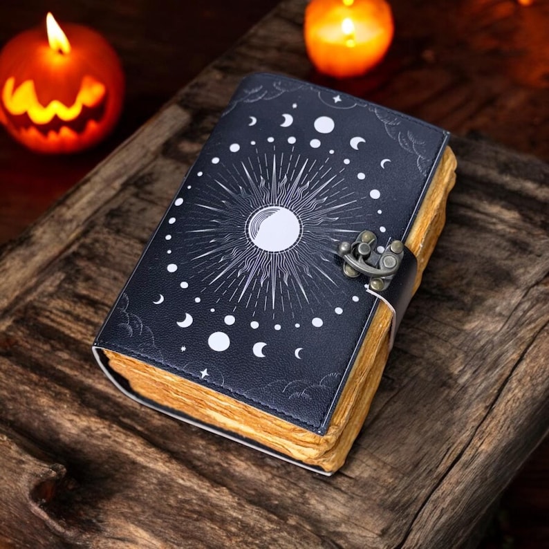 May include: A dark blue leather-bound journal with a moon and stars design. The journal has a metal clasp and is closed.