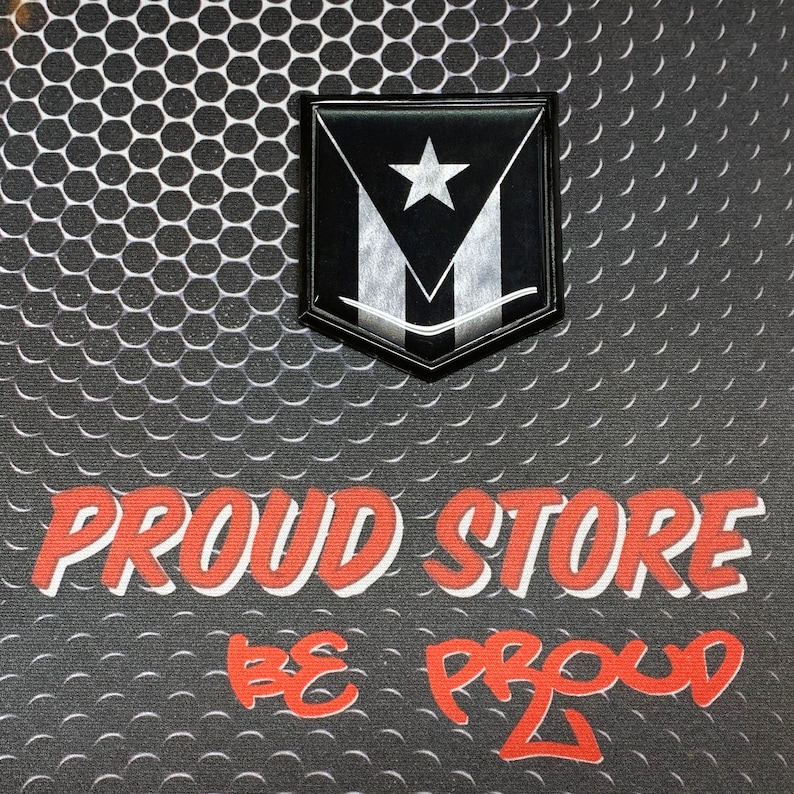 K&ouml;nnte beinhalten: Schwarz-wei&szlig;e Flagge mit einem Stern in Schildform auf einem schwarz-wei&szlig;en gemusterten Hintergrund. Der Text "PROUD STORE BE PROUD" ist in Rot unter der Flagge geschrieben.