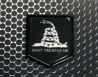 May include: A black and white 'Don't Tread On Me'  emblem with a coiled rattlesnake and the text 'Don't Tread On Me'.