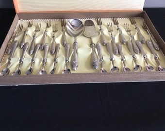 May include: A set of silver-plated cutlery in a wooden box. The set includes forks, spoons, a serving spoon, and a cake server. The cutlery is arranged in a neat row in the box.