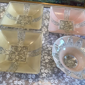May include: Four vintage glass bowls with a frosted finish. Two are square and two are round. The square bowls are in shades of cream and pink. The round bowl is pink.