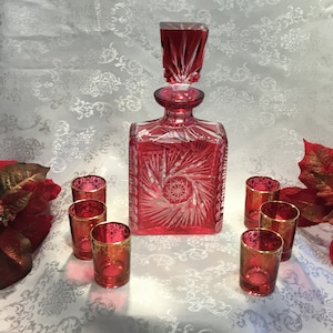A Fantastic Red Sharply Cut to Clear Crystal Decanter With Heavy Matching Stopper And 6 Rose Coloured Shot Glasses With Gold Decorative Trim