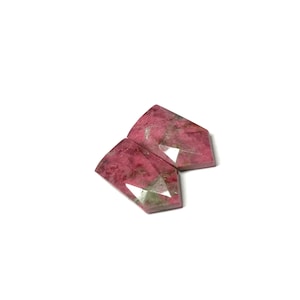 Könnte beinhalten: Zwei rosafarbene und weiße Edelstein-Cabochons in einer facettierten, länglichen Tropfenform.