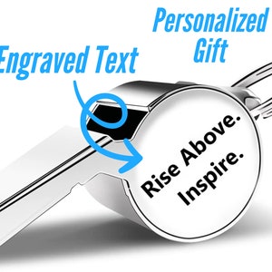 May include: Silver whistle with a keychain ring. The whistle has a round, engraved surface with the text "Rise Above. Inspire."