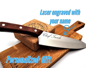 Puede incluir: Un cuchillo de chef personalizado con mango de madera y hoja de acero inoxidable. El cuchillo está grabado con el texto "Chef Tariq". El cuchillo está apoyado en una tabla de cortar de madera. El texto "Grabado con láser con su nombre" y "Regalo personalizado" es visible en la imagen.