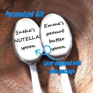 May include: Two stainless steel spoons with engraved text. One spoon says "Sneha's NUTELLA spoon" and the other says "Emma's peanut butter spoon". The text "Personalized Gift" and "Laser engraved with your message" are also visible.
