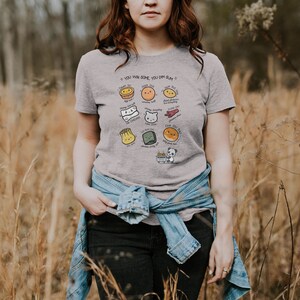 May include: A gray t-shirt with a graphic of different types of dim sum, including a steamed bun, a pork bun, a shrimp dumpling, and a spring roll. The text on the shirt reads "You win some, you dim sum."