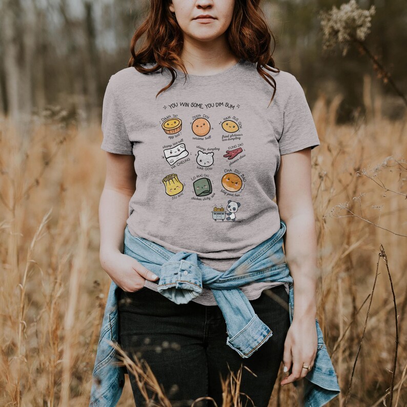 May include: A gray t-shirt with a graphic of different types of dim sum, including a steamed bun, a pork bun, a shrimp dumpling, and a spring roll. The text on the shirt reads "You win some, you dim sum."