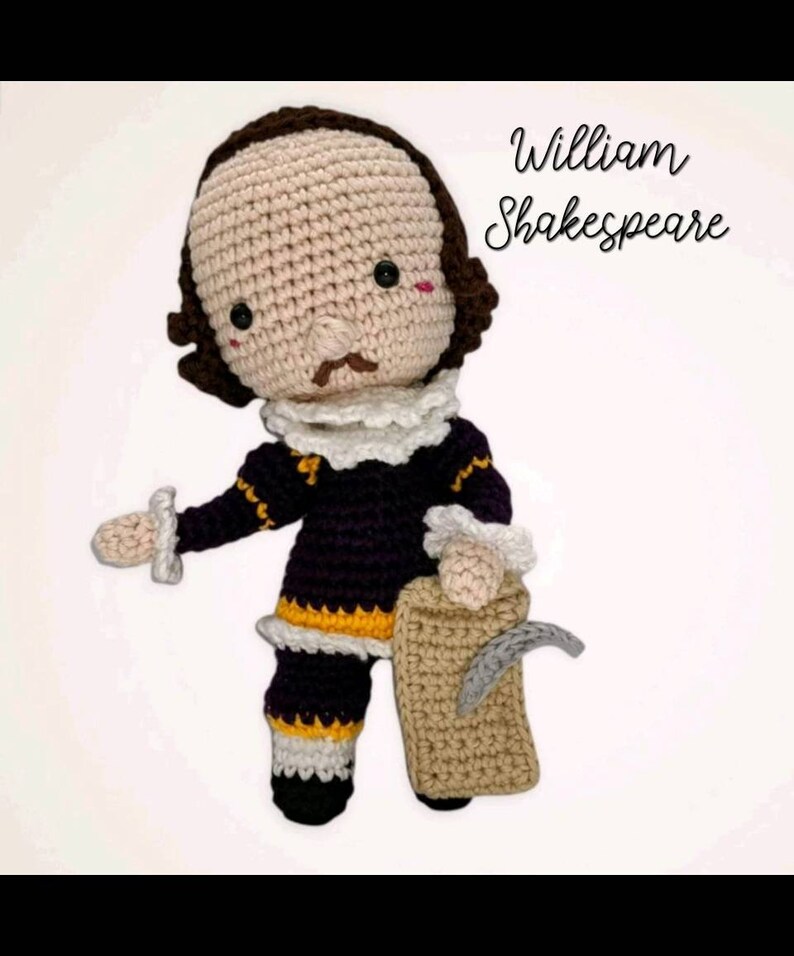 May include: A handmade crochet doll of William Shakespeare, featuring a tan face, brown hair, and a white ruffled collar. The doll wears a dark purple outfit with yellow and white accents and holds a tan scroll. The text "William Shakespeare" is written in cursive.