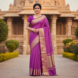 May include: A woman wearing a vibrant purple saree with gold trim, standing in front of a temple. The saree features a checkered pattern and gold borders. The sleeves of the blouse are short and puffed. The woman is wearing gold jewelry.