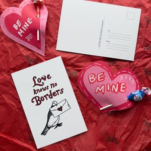 May include: Valentine's Day themed stationery set. Includes two heart-shaped cards with "BE MINE" and "xoxo" text, a postcard, and a card with a bird illustration and the text "Love knows no borders". All items are on a red background.
