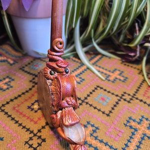 May include: A hand-crafted ceramic pipe with an owl design. The pipe is decorated with green and brown glaze and features a clear crystal at the end of the stem.