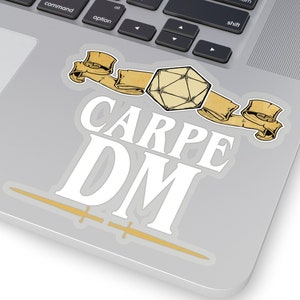 Puede incluir: Una pegatina blanca con el texto "CARPE DM" y un dibujo de un dado de veinte caras y dos rollos.