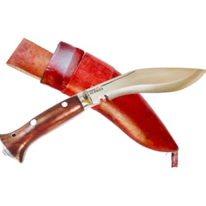 May include: A brown-handled knife with a silver blade and a red leather sheath. The blade has a serrated edge and the text "GURKHA" is printed on it.