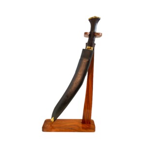 May include: A black and brown curved knife with a wooden handle and a leather sheath, displayed on a wooden stand.