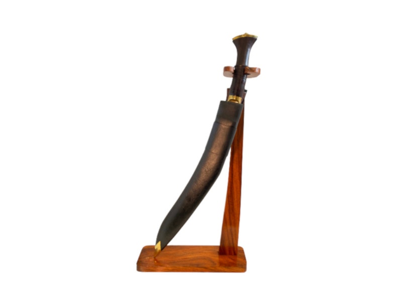 May include: A black and brown curved knife with a wooden handle and a leather sheath, displayed on a wooden stand.