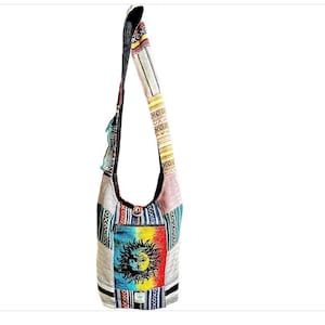 May include: A multi-colored patchwork shoulder bag with a sun and moon design. The bag has a long strap and a flap closure.