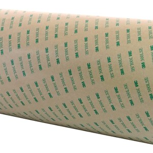 K&ouml;nnte beinhalten: Eine Rolle braunes Klebeband mit gr&uuml;nem Text, der "3M 300LSE" lautet, und einem gelben Etikett mit der Aufschrift "Scotch".