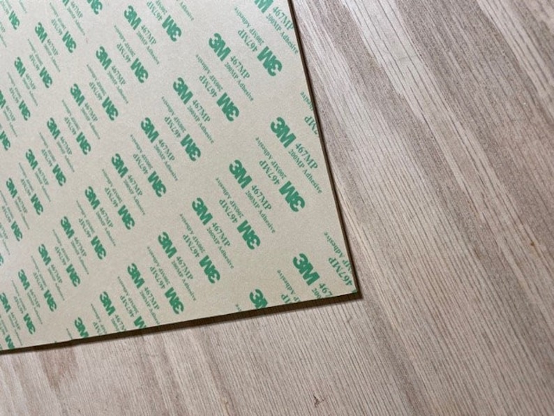 May include: A sheet of brown adhesive tape with a repeating pattern of green text that reads "3M 467MP 200MP Adhesive".