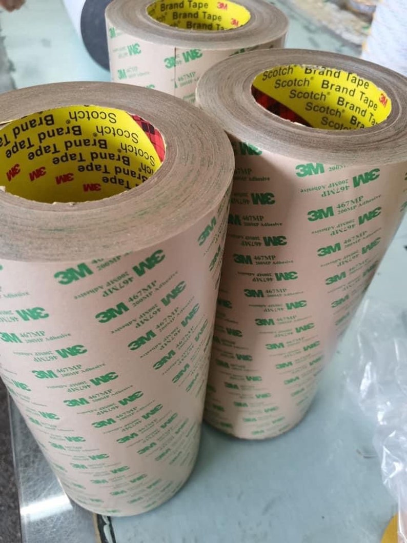 K&ouml;nnte beinhalten: Drei Rollen braunes Klebeband mit gr&uuml;nem Text, der "Scotch Brand Tape" und "3M 467MP 200MP Adhesive" lautet.