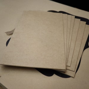 May include: A stack of eight brown, rectangular pieces of wood. The wood is smooth and appears to be unfinished.