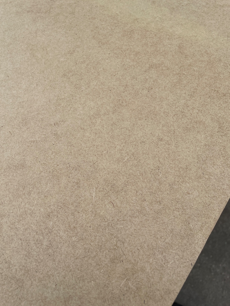 May include: A close-up of a light brown, textured surface. The surface is made of wood and has a rough, grainy texture.