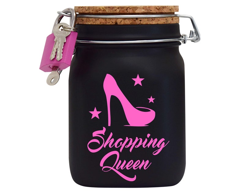 Puede incluir: Un tarro negro con cierre de llave con un dise&ntilde;o de zapato de tac&oacute;n alto rosa y estrellas. El tarro tiene una tapa de corcho y un cierre de metal. El texto "Shopping Queen" est&aacute; escrito en rosa en el tarro.