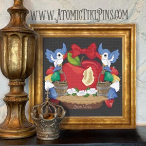 Może przedstawiać: Sztuka haftu krzyżykowego w złotej ramie przedstawiająca czerwone jabłko z kęsem, niebieskie ptaki i czerwoną kokardę. Grafika zawiera białe kwiaty i tekst "Snow White". Widoczny jest adres strony internetowej "WWW.ATOMICTIKIPINS.COM".