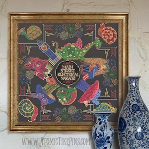 Puede incluir: Arte de punto de cruz enmarcado que representa el Main Street Electrical Parade. La obra presenta carrozas iluminadas y fuegos artificiales coloridos sobre un fondo oscuro, enmarcado en dorado.