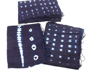 Könnte beinhalten: Drei indigo-blaue Stoffquadrate mit weißen Batik-Mustern. Die Stoffquadrate haben unterschiedliche Muster, darunter ein sich wiederholendes Muster aus kleinen Kreisen, ein Muster aus größeren Kreisen und ein Muster aus vertikalen Linien mit Kreisen.