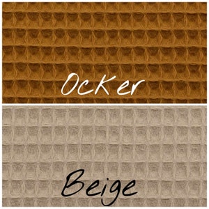 May include: Two swatches of waffle weave fabric. The top swatch is a deep orange color labeled "Ocker". The bottom swatch is a light beige color labeled "Beige".