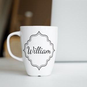 May include: White ceramic mug with a black decorative frame and the name "William" printed in black.