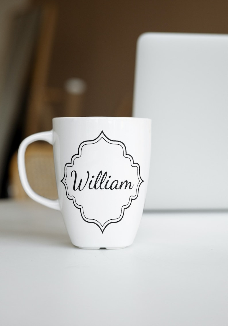 May include: White ceramic mug with a black decorative frame and the name "William" printed in black.