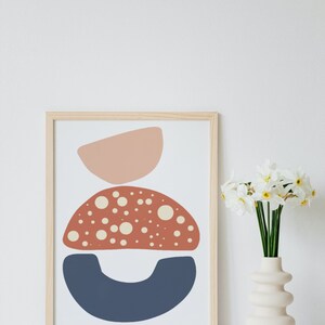 May include: A framed abstract print with three overlapping shapes in shades of pink, red, and blue. The red shape is dotted with white circles.