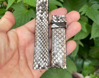 Könnte beinhalten: Zwei Uhrenarmbänder aus weißem und braunem Schlangenleder mit einem hellbraunen Nähten-Detail.