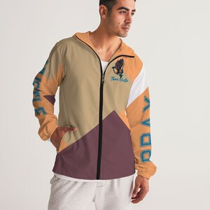 May include: A beige, orange, white and maroon windbreaker jacket with a black zip. The jacket has a graphic of a praying hand with the text "Then Hustle" on the left side and the text "Pray" on the right side.