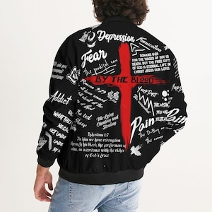 May include: Black bomber jacket with a red cross and white text. The text includes the words "Fear", "Depression", "By the Blood", "Pain", "The Lost", "The Lying and Cheating and Stealing", and "Your Past".