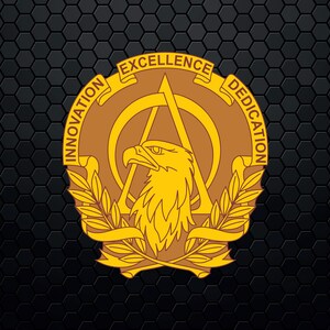 May include: A gold eagle with outstretched wings is centered in a circular design. The eagle is surrounded by a wreath of leaves and a ribbon with the words "Innovation", "Excellence", and "Dedication" inscribed on it.