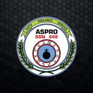 Puede incluir: Un círculo blanco con una corona de laurel verde alrededor. El círculo tiene las palabras "ASPPRO" y "SSN 648" en texto negro. La corona tiene las palabras "FAITH", "VIGILANCE" y "SERVICE" en texto verde. El círculo también tiene un círculo azul con un círculo negro en el centro y una cruz en la parte superior. El círculo azul tiene símbolos rojos y negros alrededor.