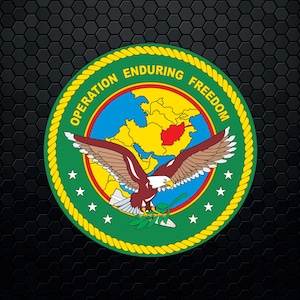 May include: A yellow, rope-like circle with the words "Operation Enduring Freedom" around the edge. Inside the circle is a green background with a white eagle with brown wings flying over a map of Central Asia. The eagle is holding a branch with green leaves in its talons. There are five white stars around the eagle.