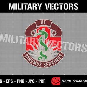 Op de afbeelding: Een rood, wit en bruin militair insigne met een groene slang die om een staf is gewikkeld. De slang heeft een rode tong en de staf heeft een rood kruis. De tekst "UT SANEMUS SERVIMUS" staat rond de slang en de staf.